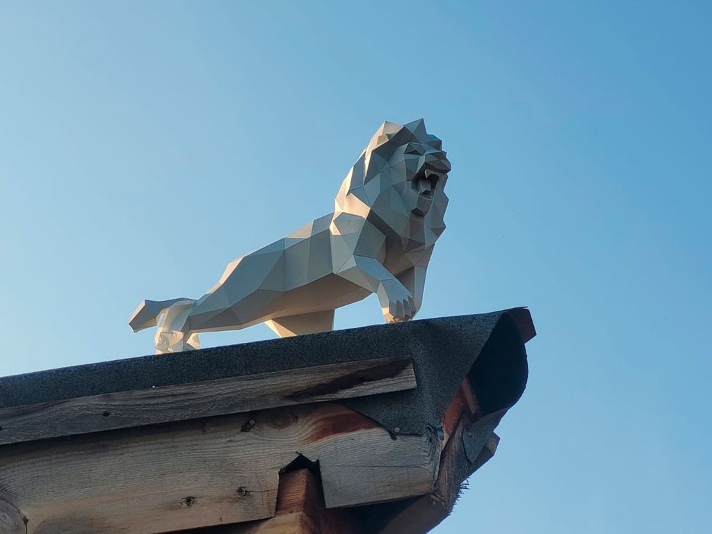 Sculptures of a lion and a dragon – symbols of the customer’s wife according to the Chinese horoscope for decorating the roof of a house, Ekaterinburg, Russia